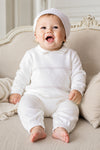 Carriage Boutique white knit diamond stitch baby boy christening outfit with matching hat on a seated baby