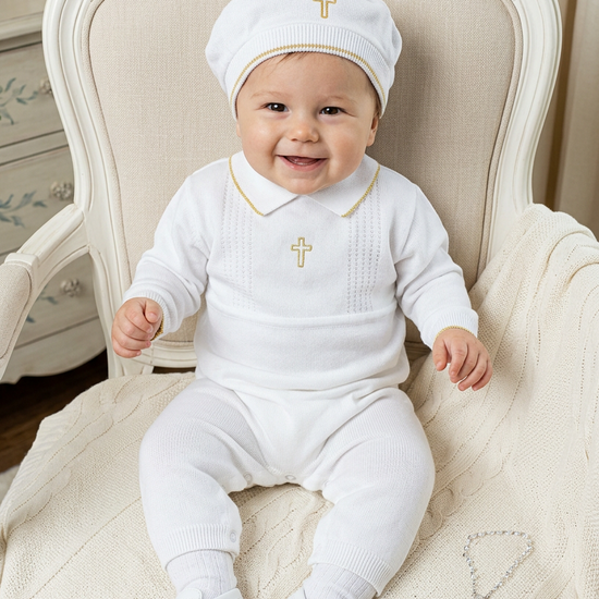 Baby boy wearing a Carriage Boutique white knit christening outfit with gold cross embroidery and matching hat