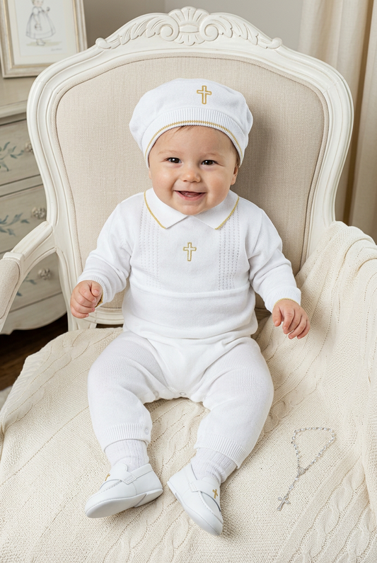 Baby boy wearing a Carriage Boutique white knit christening outfit with gold cross embroidery and matching hat