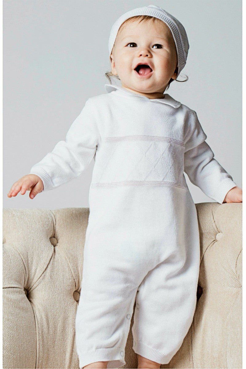Carriage Boutique white knit baby boy christening romper with diamond stitch pattern and matching hat on a baby.
