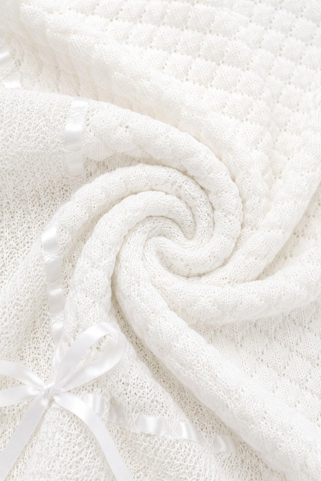 Carriage Boutique white baby blanket featuring soft knit texture, delicate Belgium lace, and a satin ribbon bow.