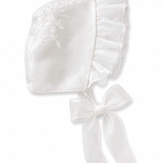 Carriage Boutique white satin christening bonnet with delicate lace embroidery, scalloped trim, and organza ribbon tie.