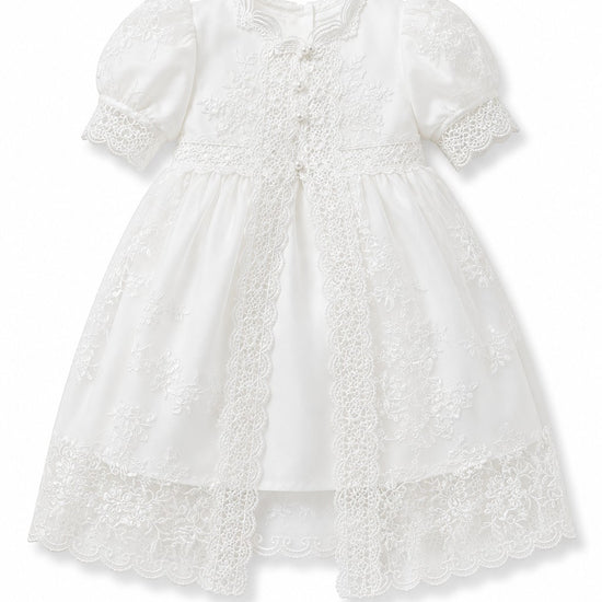 Carriage Boutique white lace christening gown with puffed sleeves, satin base, and intricate embroidery details.