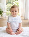 Carriage Boutique baby boy wearing a white cotton romper with blue trim and custom monogram embroidery