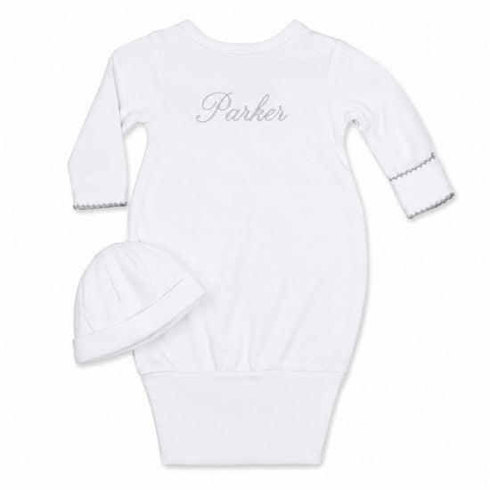 Carriage Boutique white newborn sleep sack with matching hat, featuring scalloped cuffs and custom name embroidery.
