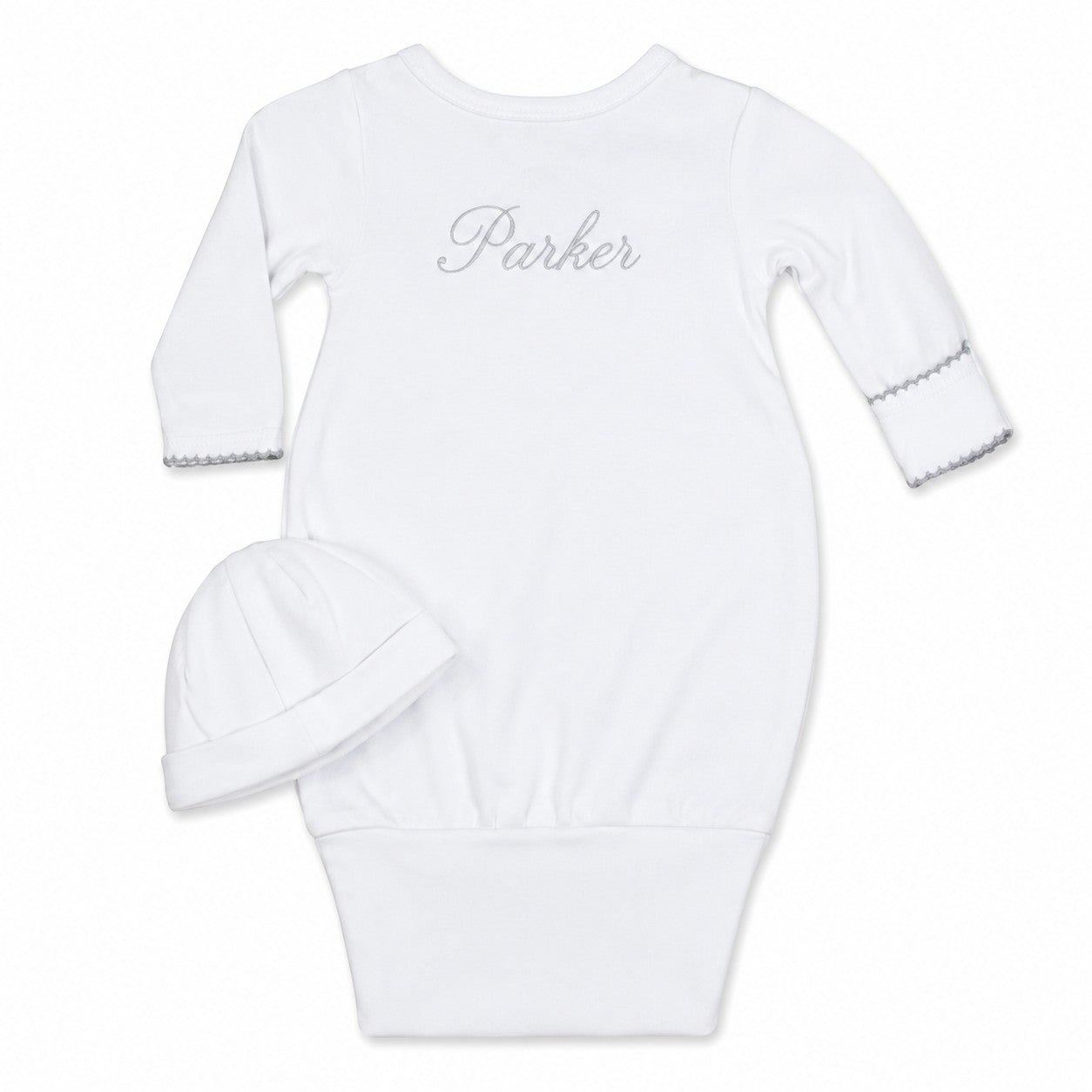 Carriage Boutique white newborn sleep sack with matching hat, featuring scalloped cuffs and custom name embroidery.