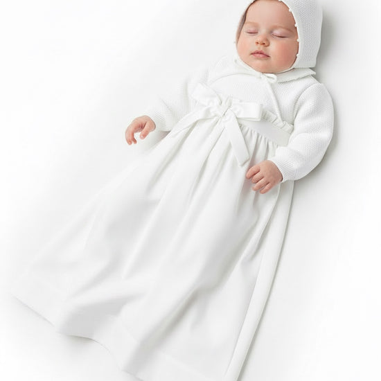 Carriage Boutique baby girl white christening gown with pebble stitch texture, long sleeves, and matching bonnet.
