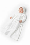 Carriage Boutique baby girl white christening gown with pebble stitch texture, long sleeves, and matching bonnet.