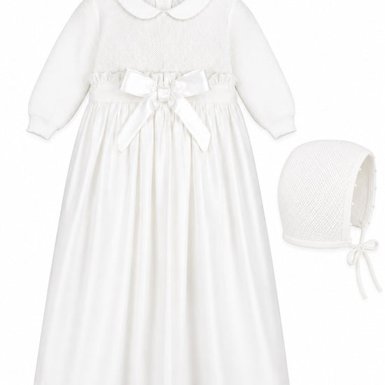 Carriage Boutique white baby girl christening gown with pebble stitch bodice, satin bow, and matching bonnet.