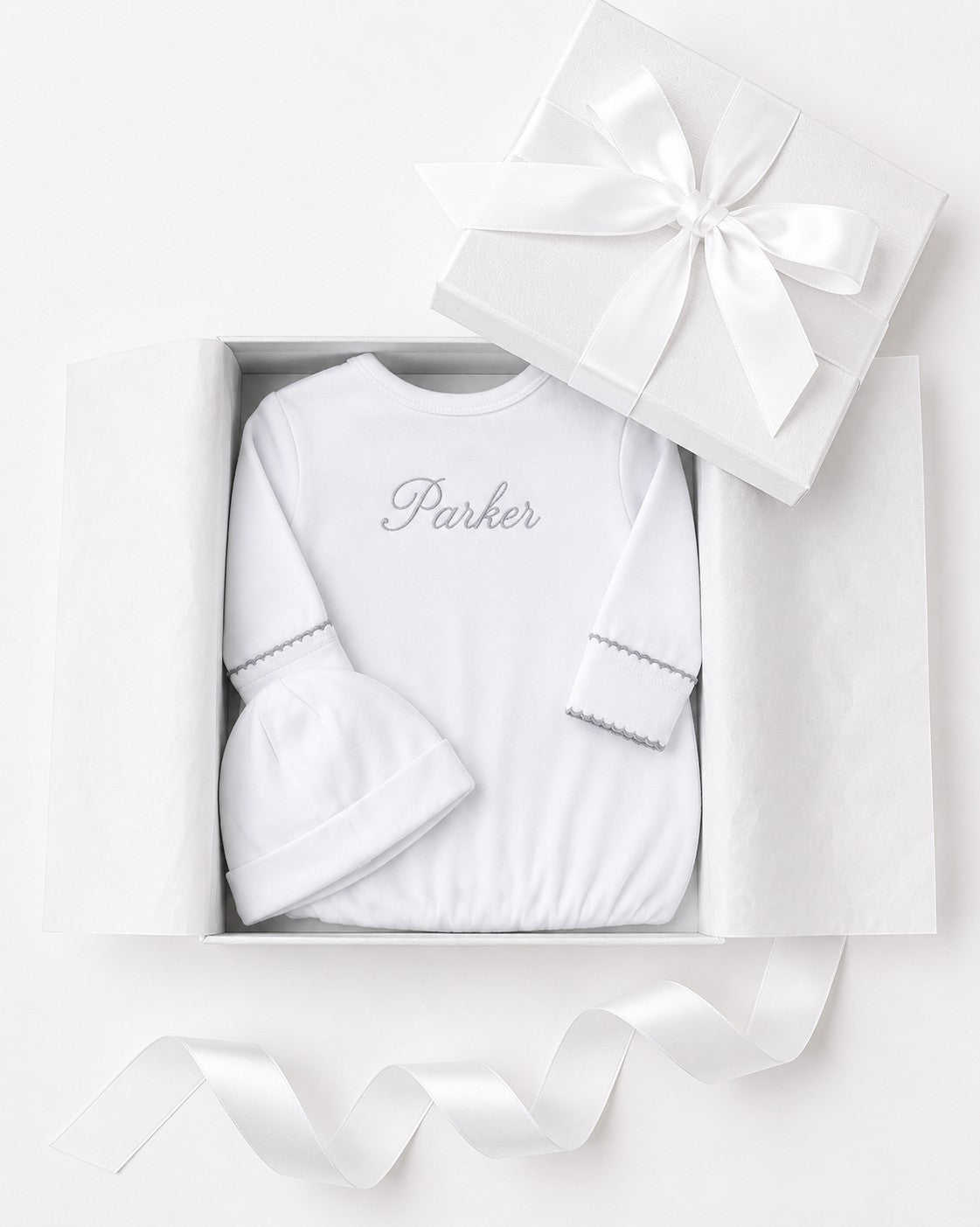 Carriage Boutique white newborn sleep sack and matching hat with personalized embroidery in a gift box.
