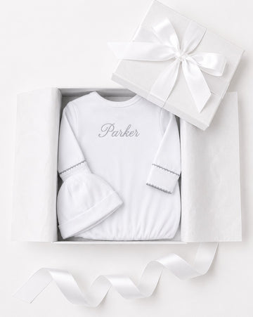 Carriage Boutique white newborn sleep sack and matching hat with personalized embroidery in a gift box.