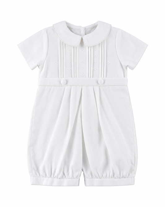 Carriage Boutique white pique baby boy romper with a Peter Pan collar, pleated bodice, and button detailing.
