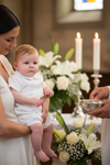 Carriage Boutique white pique baby boy romper worn by an infant during a christening ceremony