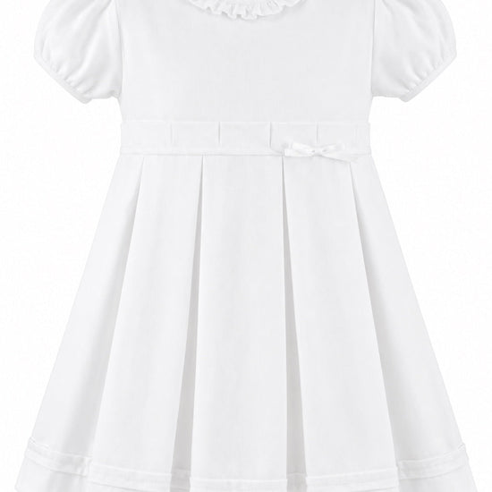 Carriage Boutique white pique baby and toddler girl dress with a ruffled collar, puff sleeves, and a bow waist detail.
