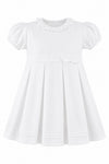 Carriage Boutique white pique baby and toddler girl dress with a ruffled collar, puff sleeves, and a bow waist detail.