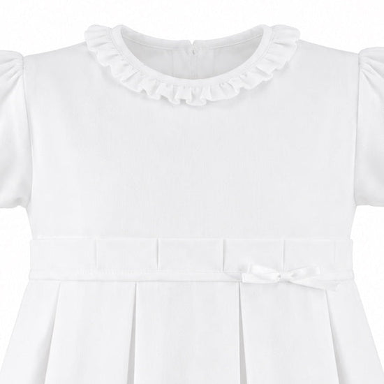 Carriage Boutique white pique toddler girl dress with a ruffled collar, pleated skirt, and a delicate waist bow.