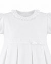 Carriage Boutique white pique toddler girl dress with a ruffled collar, pleated skirt, and a delicate waist bow.