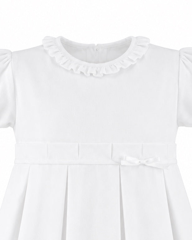 Carriage Boutique white pique toddler girl dress with a ruffled collar, pleated skirt, and a delicate waist bow.