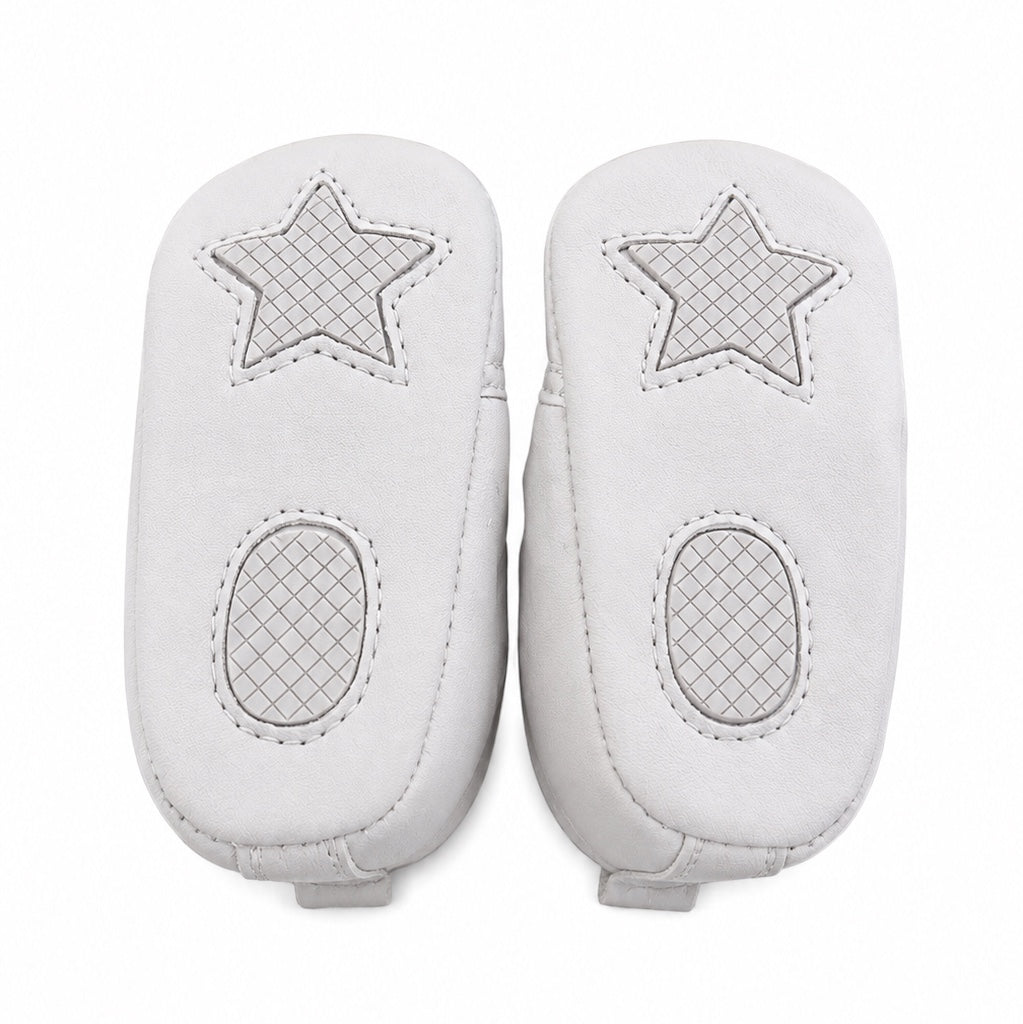 Carriage Boutique white quilted baby boy christening shoes with star and oval grip patterns on the soles