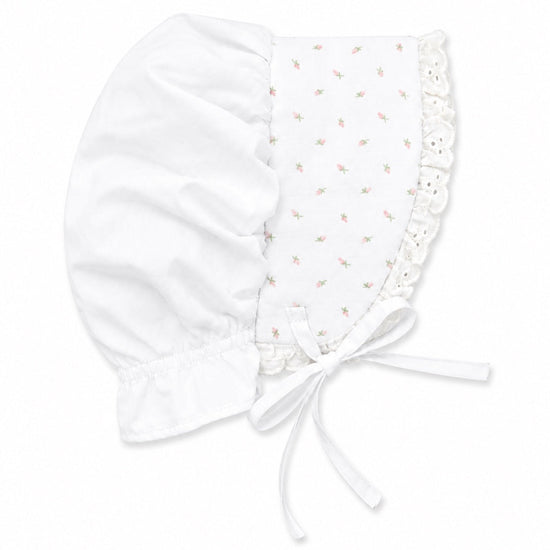 Carriage Boutique white baby bonnet featuring a delicate pink rosebud print, lace trim, and soft fabric ties.
