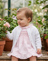 Carriage Boutique white cotton cashmere baby girl cardigan with delicate rosebud embroidery worn over a pink dress
