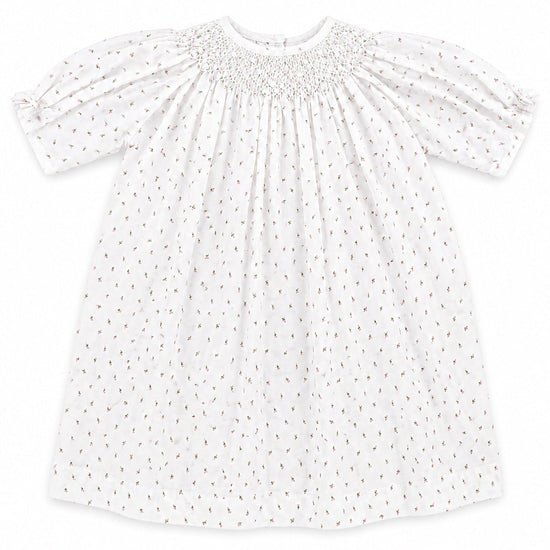 Carriage Boutique white baby girl dress with delicate rosebud print, smocked bodice, and short puff sleeves.