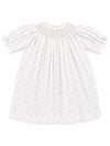 Carriage Boutique white baby girl dress with delicate rosebud print, smocked bodice, and short puff sleeves.