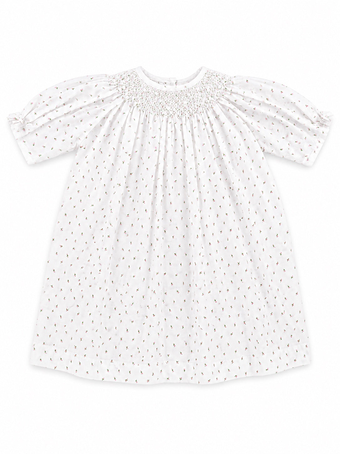 Carriage Boutique white baby girl dress with delicate rosebud print, smocked bodice, and short puff sleeves.