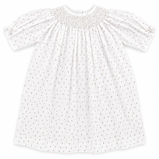 Carriage Boutique white newborn girl dress with delicate pink rosebud print, smocked bodice, and short puff sleeves.