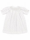 Carriage Boutique white newborn girl dress with delicate pink rosebud print, smocked bodice, and short puff sleeves.