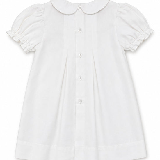 Carriage Boutique white heirloom baby dress featuring a Peter Pan collar, puffed sleeves, and back button closure.