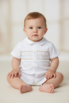 Baby boy wearing a white Carriage Boutique bobby suit with hand-smocked beige detailing for formal occasions.