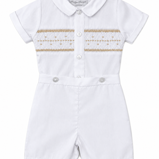 Carriage Boutique white baby boy bobby suit with hand smocked gold detailing, short sleeves, and snap crotch.