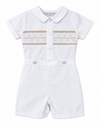 Carriage Boutique white baby boy bobby suit with hand smocked gold detailing, short sleeves, and snap crotch.