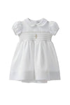 Carriage Boutique white baby girl christening dress with smocked bodice and delicate cross embroidery detail.