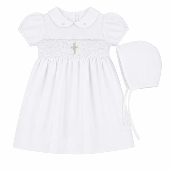 Carriage Boutique white baby girl christening dress with smocked bodice, cross embroidery, and matching bonnet.