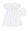 Carriage Boutique white baby girl christening dress with smocked bodice, cross embroidery, and matching bonnet.