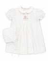 Carriage Boutique white smocked heirloom dress with pram embroidery and matching ruffled bonnet for baby girls.