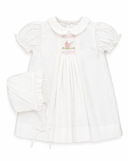 Carriage Boutique white smocked heirloom dress with pram embroidery and matching ruffled bonnet for baby girls.