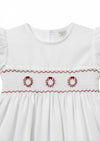 Carriage Boutique white toddler dress featuring hand smocking and red embroidered wreath details on the bodice