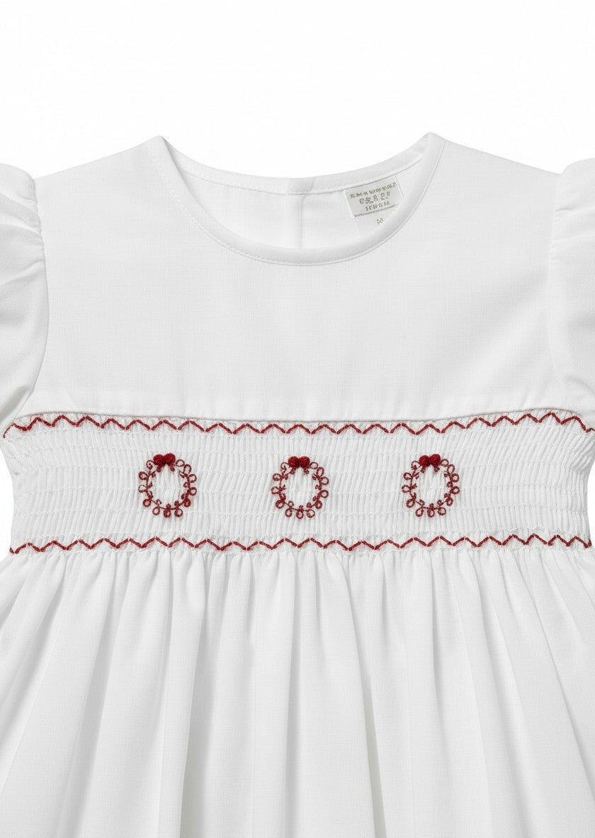 Carriage Boutique white toddler dress featuring hand smocking and red embroidered wreath details on the bodice
