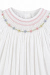 Carriage Boutique white baby girl bishop dress with hand-smocked floral embroidery and delicate flutter sleeves.