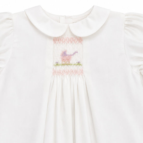 Carriage Boutique white heirloom dress with hand-smocked bodice, Peter Pan collar, and pastel pram embroidery.