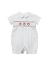 Carriage Boutique white batiste boys shortall with hand-smocked red holiday wreath embroidery and Peter Pan collar.