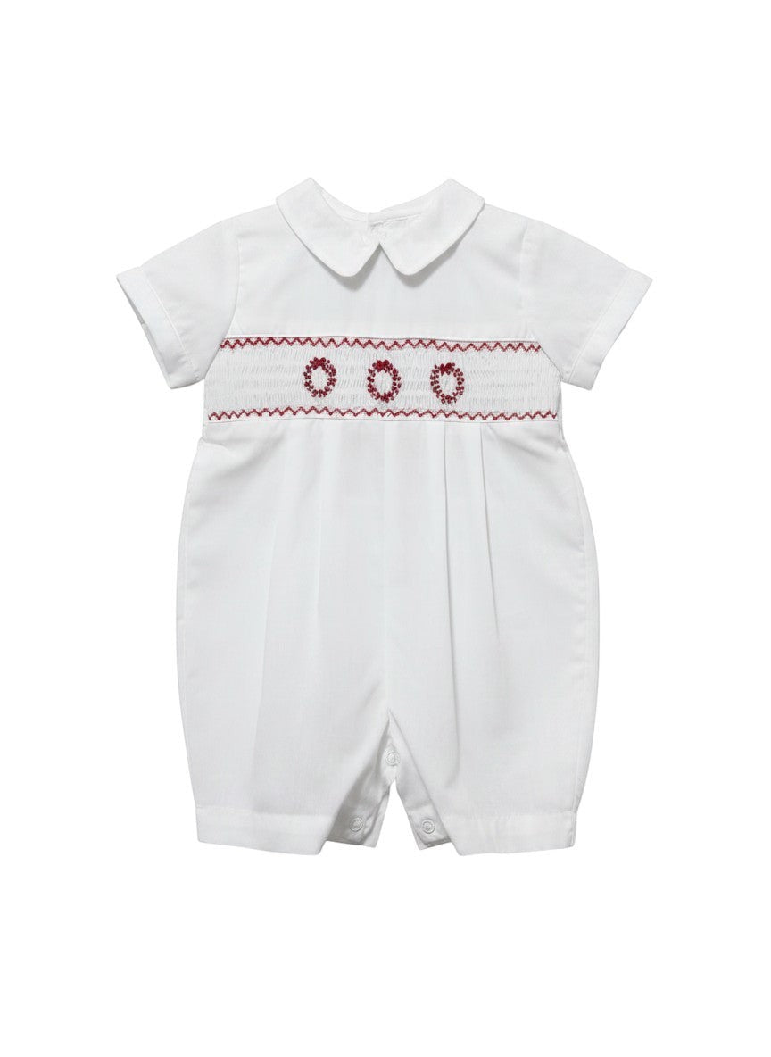 Carriage Boutique white batiste boys shortall with hand-smocked red holiday wreath embroidery and Peter Pan collar.