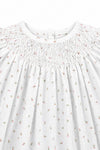 Carriage Boutique white newborn dress featuring delicate pink rosebud print and intricate hand-smocked bodice detail.