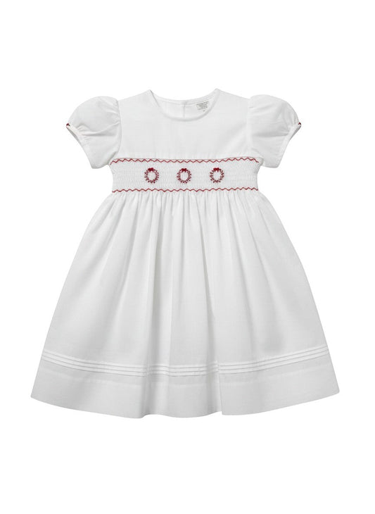 Carriage Boutique white toddler dress with short puff sleeves, hand smocking, and delicate red wreath embroidery.