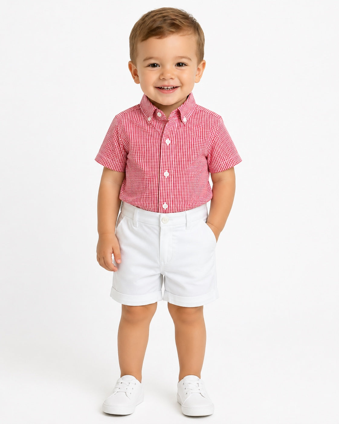 Toddler boy wearing Carriage Boutique white twill shorts and a red gingham shirt against a plain white background