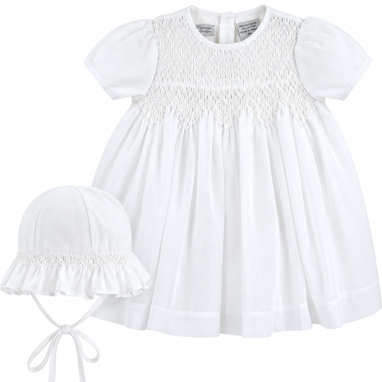 Carriage Boutique white voile christening dress with smocked bodice and matching bonnet for baby girls