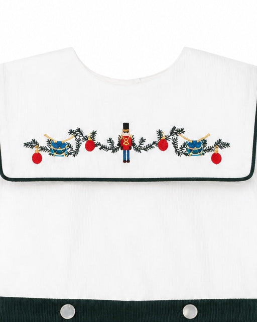 Carriage Boutique white cotton bobbie suit featuring a smocked bib with embroidered wooden soldier and holiday decor